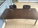 a desk with two chairs and a table with a cup on it