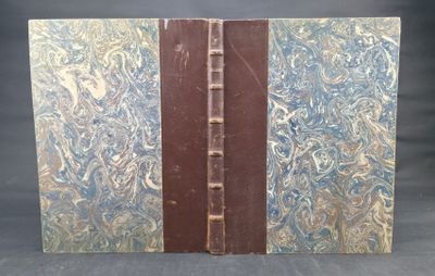 an old book with a blue and brown cover sitting on top of a table