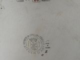 a silver plate with a stamp on it sitting on a table