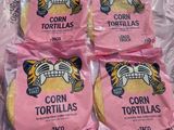 quatre sachets de tortillas de maïs posés sur un sac en plastique