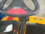 a yellow and black toy truck with a steering wheel