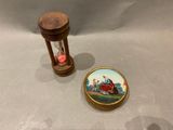 a small hourglass with a miniature picture on it next to a small hourglass
