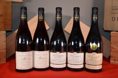 six bouteilles de vin sont alignées sur une table rouge