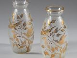 two glass vases with gold leaves and berries on them