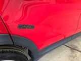 a close up of a red car with a sticker on it