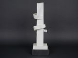 a white sculpture on a black surface with a black background