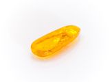 a close up of a yellow pill sitting on top of a white surface
