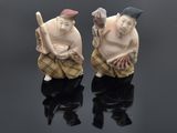 deux figurines représentant deux hommes assis sur une surface noire