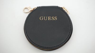 un gros plan d'un porte-monnaie sur lequel est inscrit le mot « guess »