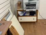 une imprimante posée sur un bureau en bois dans une pièce