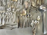 a lot of silver spoons and silverware on the table