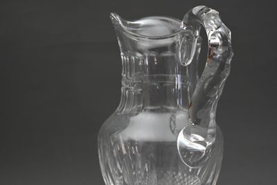 un pichet en verre transparent muni d'une anse, posé sur une table