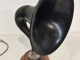 an old fashioned black hornphone on a wooden stand