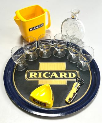 un plateau sur lequel se trouvent des verres, une bouteille, une canette et un décapsuleur