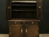 an old wooden cabinet with a door open on a parquet floor