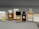 a lot of perfume bottles and a cell phone on the table