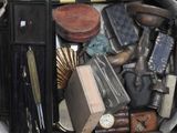a suitcase full of assorted items that include a gun, a clock, and other items