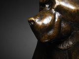 a close up of a bronze statue of a monkey on a black background