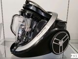 un mixeur noir et argent exposé dans une vitrine en verre