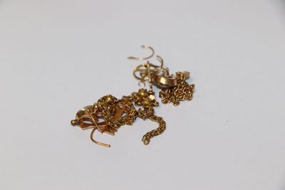 un collier et des boucles d'oreilles en or posés sur une assiette blanche