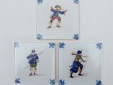 four blue and white tile coasters with a picture of a man and a woman holding swords