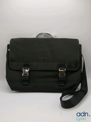 Le petit sac noir est posé sur la table, avec une sangle qui l'entoure.