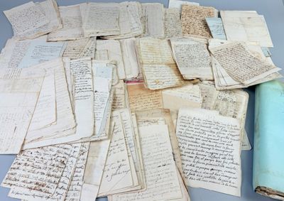 a pile of old papers on a table next to a roll of paper