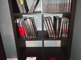 a black bookcase filled with dvds in a room