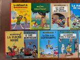 several children ' s books are lined up on a wooden shelf