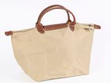 an image of a tan bag with brown handles on a white background