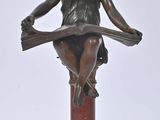 an image of a bronze statue of a woman sitting on top of a table