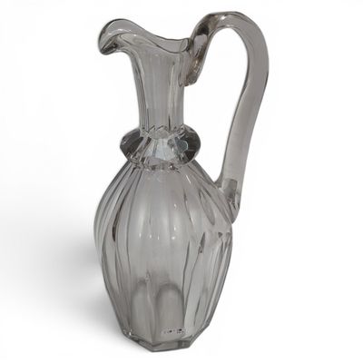 a clear glass pitcher with a handle on a white surface