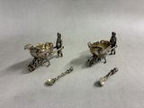 silver plated figurines of a man and a child in a carriage