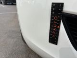 a measuring tape on the front of a white car