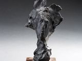 statue of an elephant head on a wooden base on a white surface
