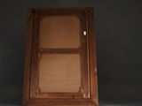 an old wooden cabinet with a glass door in the middle of it
