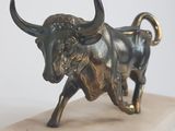statue d'un taureau posée sur un socle en marbre, sur fond blanc
