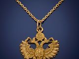 a gold necklace with a double headed eagle on it