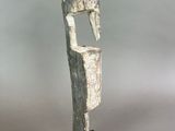 statue of a man with a head on a base with a tag on it