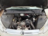 une voiture blanche dont le capot est ouvert et le moteur se trouve dans le coffre