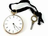 une montre à gousset en or à laquelle est attachée une clé