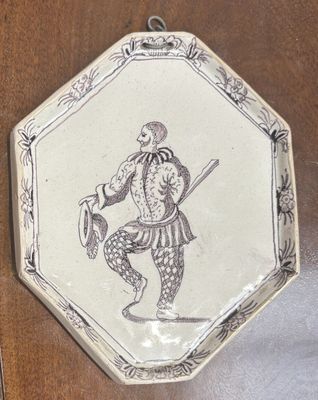 a plate with a drawing of a man holding a sword and shield