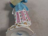 a figurine of a woman holding a book on a table