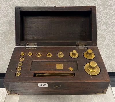 une petite boîte en bois ornée de boutons en laiton