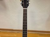 an acoustic guitar sitting on a hard wood floor in a room
