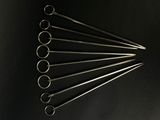 six pairs of surgical instruments are arranged on a black surface