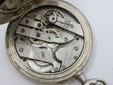 a close up of a pocket watch on a white surface