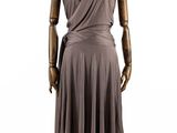 le mannequin porte une robe avec un pan qui l'enveloppe