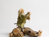 a figurine of a man sitting on top of a tree stump