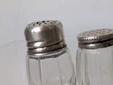 two salt and pepper shakers sitting on a table